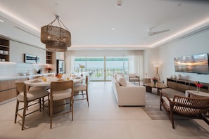 A modern living room with a sofa, dining table, chairs, and a TV. - Step Into Unparalleled Luxury and Expansive Comfort at our Signature Residences (Telire)
