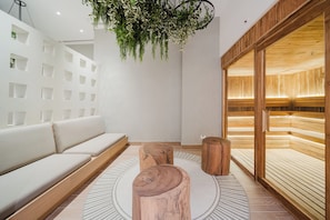 A modern interior with a white sofa, wooden stools, a hanging plant, and a wooden bench area. - Step Into Unparalleled Luxury and Expansive Comfort at our Signature Residences (Quepos)