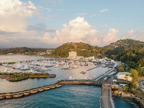 A marina with numerous boats docked, a pier, and a hillside with buildings. - Step Into Unparalleled Luxury and Expansive Comfort at our Signature Residences (Quepos)