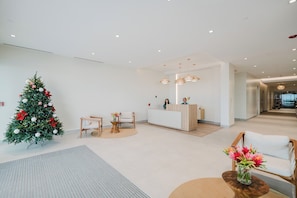 A modern hotel lobby with a reception desk, a Christmas tree, and a seating area. - Step Into Unparalleled Luxury and Expansive Comfort at our Signature Residences (Telire)