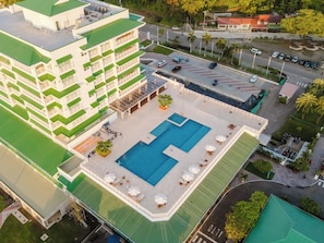 A multi-story hotel with a rooftop pool, outdoor seating, and a parking area. - Discover Unparalleled Elegance at our Marina Vista Villas! (Telire)