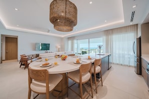 A modern kitchen with a built-in oven and a dining area with a round table and chairs.