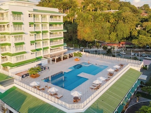A hotel with a swimming pool, outdoor seating, and a view of the surrounding greenery. - Experience the Ultimate in Spacious Luxury at our Panorama Villas! (Telire)