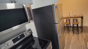 Una cocina compacta equipada con microondas, estufa y refrigerador.