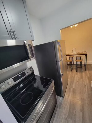 A compact kitchen with a microwave, stove, and refrigerator.