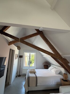 A bedroom with a sloped ceiling, a bed, a window, and a lamp. - Your home in Bruges, set in a historic setting just 5 minutes from the Main Market Square. (Brugge)
