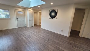 Ein geräumiges Zimmer mit Oberlichter, Holzböden und einer großen, runden Wanddekoration.