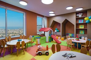 Un área de juegos infantiles con tobogán, casita y juguetes.