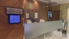 Un centro business con schermo digitale, pannelli in legno e una parete divisoria in vetro.