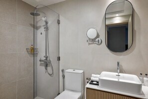 Ein modernes Badezimmer mit Dusche, Toilette, Waschbecken und Spiegel.