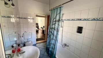 Un bagno con lavandino, specchio, doccia e WC.