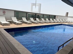 Una piscina con lettini e un cartello che indica divieto di tuffi.