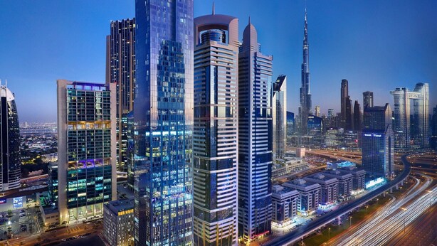 A cityscape with modern high-rise buildings, including a prominent skyscraper. - 1BR Suite | Marriott Dubai | Full Kitchen, Metro Walk, DIFC Nearby | 2 Units (Dubai)