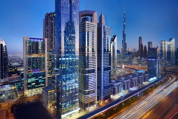 A cityscape with modern high-rise buildings, including a prominent skyscraper.