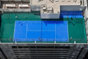 Vista aerea di un campo da tennis circondato da edifici.