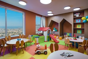 Un área de juegos infantiles con tobogán, casita y juguetes.