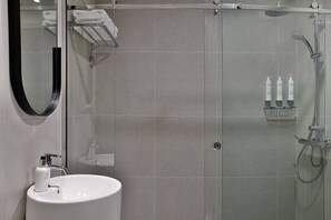 A modern bathroom with a glass-enclosed shower, a white sink, and a mirror. - Marriott Dubai | Premium 1BR | Apt-styled Comfort on Sheikh Zayed Rd | 2 Units (Dubai)