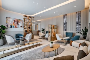 A modern living room with a sofa, chairs, a coffee table, and a bookshelf.