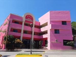 A pink building with a sign reading 'HOTEL TAMAZUNCHALE.'