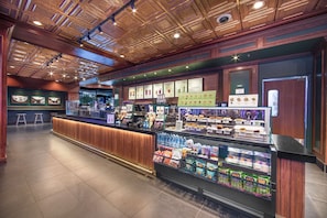 A restaurant with a counter, menu boards, and a refrigerated display.