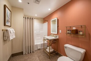 Une salle de bain avec une baignoire, des toilettes, un lavabo et un miroir.