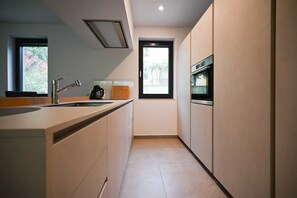 Eine moderne Küche mit integriertem Spülbecken, einer Kaffeemaschine und einem Fenster.