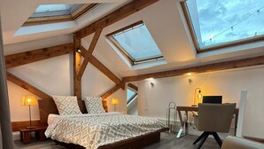 A bedroom with a skylight, a bed, a desk, and a chair. - STUNNING DUPLEX IN THE HEART OF THE CITY CENTER WITH UNDERGROUND PARKING INCLUDED, 10 MINUTES FROM PARIS (Rueil-Malmaison)