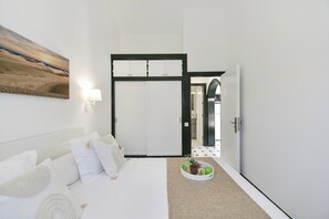 Ein Hotelzimmer mit einem Bett, einem Wandbild, einer Nachttischlampe und einem kleinen Tisch mit einer Pflanze.