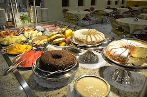 Ein reichhaltiges Buffet mit verschiedenen Speisen und einer Torte auf einem Tisch.