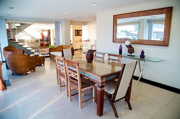 A dining area with a glass table, wicker chairs, and a modern interior.