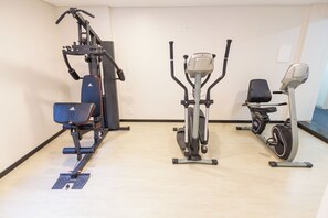 Ein Fitnessstudio mit Fahrradergometer, Crosstrainer und Kraftgerät.