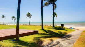 A wooden deck leading to a beach with palm trees and a clear view of the ocean. - Wai Wai #a204 Comfort Beachfront By Carpediem (Caucaia)