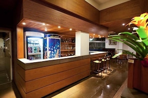 Eine Bar mit Holzwänden, einer Theke und Hockern.
