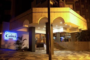 L’hôtel Caiuá se distingue par sa façade moderne, son escalier apparent et une enseigne indiquant la présence d’un restaurant.