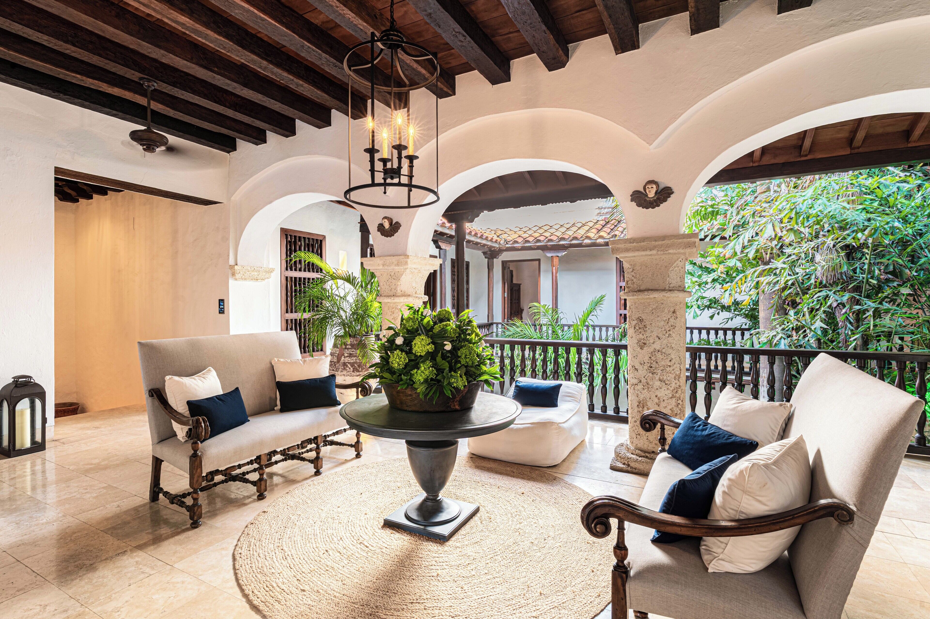 A spacious patio with a round table, two sofas, and a potted plant.