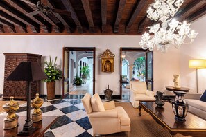 Eine geräumige Lobby mit Schachbrettmuster-Boden, einer Kristallleuchter, einem Sofa, einem Couchtisch und einem großen Spiegel.