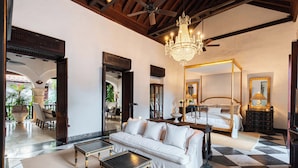 A room with a sofa, a bed, a chandelier, and a ceiling fan. - CASA ESTRADA LUXURY VILLA (Cartagena)