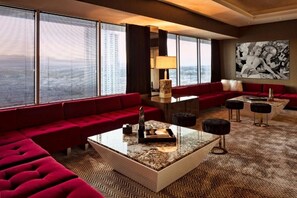A modern hotel lobby with a red sofa, a marble coffee table, and a large window with blinds. - Marra King | Sahara | On the Strip | Free Parking (Las Vegas)