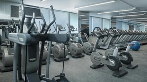A gym with multiple treadmills, ellipticals, and weight machines.