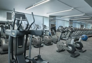 Ein Fitnessstudio mit mehreren Laufbändern, Crosstrainern und Kraftgeräten.