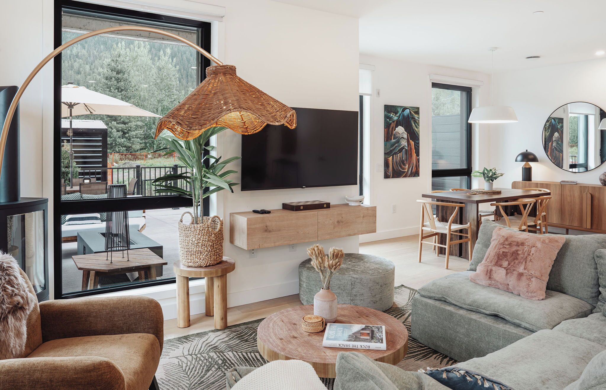 A modern living room with a TV, dining area, and a large window.