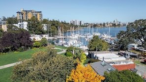 Un port de plaisance où sont amarrés de nombreux bateaux, entouré d’immeubles résidentiels et de verdure.