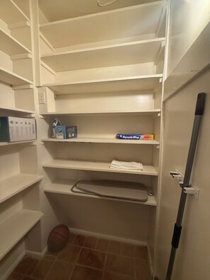 Een berging met planken, een basketbal en schoonmaakspullen.