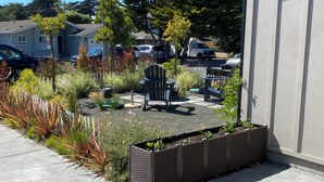 Un giardino con una fioriera, una sedia e un tavolo.