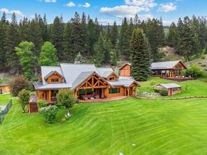 Ein geräumiges Blockhaus mit mehreren Zimmern, einer Veranda und einem gepflegten Rasen.