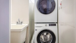 Ein kleiner Hauswirtschaftsraum mit Waschmaschine und Spüle.