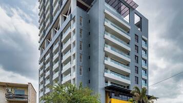 A modern high-rise building with multiple balconies and a prominent glass facade.