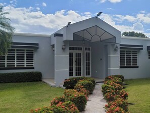 A modern building with a symmetrical facade, large windows, and a central entrance with a covered porch.