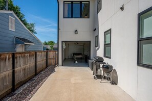 Un bâtiment moderne doté d’un patio couvert, d’un espace barbecue et offrant une vue sur l’intérieur.