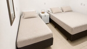 Un dormitorio con dos camas, una mesita de noche y un espejo fijado a la pared.